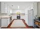Functional kitchen with white cabinetry, stainless steel appliances, and wood-look flooring, offering great potential at 656 New Hope Rd, Lawrenceville, GA 30046