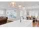 Bright, open kitchen featuring a white quartz island, stainless steel faucet, and a view into the dining area at 100 Westchester Pass, Peachtree City, GA 30269