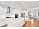 Open-concept kitchen boasts white cabinets, stainless steel appliances, and a spacious island with views of the staircase at 100 Westchester Pass, Peachtree City, GA 30269