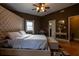 This bedroom features a large padded headboard, ceiling fan, and hardwood flooring at 4985 Union St, Union City, GA 30291