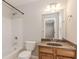 Well-lit bathroom showcasing a vanity with granite countertop, a mirror, and a shower-tub combination at 507 Grove Field Ct, Suwanee, GA 30024