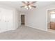 Spacious bedroom featuring neutral carpet, a ceiling fan, and access to an en-suite bathroom at 507 Grove Field Ct, Suwanee, GA 30024