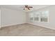 Spacious bedroom features soft carpet, neutral paint, and a bank of sunny windows at 507 Grove Field Ct, Suwanee, GA 30024