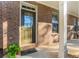 Inviting entrance to a brick home featuring a covered porch and a well-maintained landscape at 507 Grove Field Ct, Suwanee, GA 30024