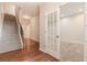 Inviting entryway featuring hardwood floors, staircase with carpet, and a view of a room through glass doors at 507 Grove Field Ct, Suwanee, GA 30024