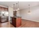 Open kitchen boasts an island with granite countertop and stainless steel appliances at 507 Grove Field Ct, Suwanee, GA 30024
