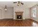 Bright living room with a stone fireplace, hardwood floors, ceiling fan and chandelier lighting at 507 Grove Field Ct, Suwanee, GA 30024
