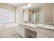 Bright bathroom with double sinks, granite counters, a soaking tub, and a window for natural light at 1993 Shenley Park Ln, Duluth, GA 30097