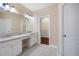 A bright bathroom offers double sinks, granite countertops, and a view into the walk-in closet at 1993 Shenley Park Ln, Duluth, GA 30097