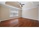 A spacious bedroom features hardwood floors, a tray ceiling, a ceiling fan, and natural light from a large window at 1993 Shenley Park Ln, Duluth, GA 30097