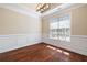 Elegant dining room featuring wainscoting, hardwood floors, and modern light fixture at 1993 Shenley Park Ln, Duluth, GA 30097
