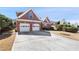 Brick home with a spacious driveway and two-car garage, complemented by green lawn at 1993 Shenley Park Ln, Duluth, GA 30097
