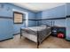 Carpeted bedroom featuring a bed with metal frame, window with wood blinds, and dark blue walls at 570 Knollwood Dr, Stockbridge, GA 30281