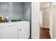 Functional laundry room features a Whirlpool washer and dryer, with hardwood floors leading out of the room at 570 Knollwood Dr, Stockbridge, GA 30281