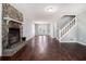 Spacious living room featuring a stone fireplace, wood floors, and staircase to the second floor at 570 Knollwood Dr, Stockbridge, GA 30281