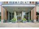 The front entrance of a modern brick building with a gray awning and large glass windows at 855 Peachtree Ne St # 1703, Atlanta, GA 30308