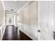 Hallway with hardwood floors, neutral walls, and white wainscoting, leading to the front door and other rooms at 165 Birch St, Hiram, GA 30141