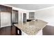 Close-up of kitchen island featuring granite countertops, dark wood cabinets, hardwood floors, and a pantry in the background at 165 Birch St, Hiram, GA 30141