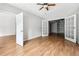 Bedroom with hardwood floors, ceiling fan and adjacent room with custom shelving at 2451 Napa Valley Dr, Villa Rica, GA 30180