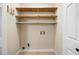 Functional laundry room featuring tiled floor, white walls, and built-in shelves for convenient storage at 2898 Lakemont Sw Dr, Marietta, GA 30060