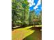 Green backyard featuring a deck and several trees at 9645 Dunhill Way, Cumming, GA 30028