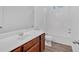 Well-lit bathroom with a wooden vanity and a shower-tub combo at 9645 Dunhill Way, Cumming, GA 30028