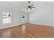 Spacious bedroom features hardwood floors, two double-hung windows, and a ceiling fan at 9645 Dunhill Way, Cumming, GA 30028
