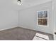 Bright bedroom featuring plush carpeting, a double-hung window, and modern lighting fixture at 9645 Dunhill Way, Cumming, GA 30028