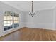 Formal dining room features hardwood floors, large windows, crown molding, and a stylish chandelier at 9645 Dunhill Way, Cumming, GA 30028