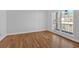 Bright room features hardwood floors, neutral walls, trim, and large window for natural light at 9645 Dunhill Way, Cumming, GA 30028