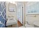 Bathroom with a pedestal sink, a window, and a blue and white patterned shower curtain at 2264 Winding Way, Tucker, GA 30084