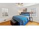 Cozy bedroom featuring two windows, a blue patterned duvet, hardwood floors, and a padded ottoman at 2264 Winding Way, Tucker, GA 30084