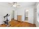 Bedroom with hardwood floors, a ceiling fan, exercise equipment and easy access to the bathroom at 2264 Winding Way, Tucker, GA 30084