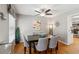 Open dining area with hardwood floors, a modern light fixture and seating for six, with a view into the kitchen at 2264 Winding Way, Tucker, GA 30084