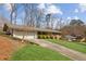 This charming home features a two-car garage, mature trees and shrubs, and is located on a sloping lot at 2264 Winding Way, Tucker, GA 30084