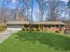 Charming brick ranch home with a well-manicured lawn and a two-car garage is surrounded by mature trees at 2264 Winding Way, Tucker, GA 30084