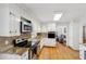 Bright kitchen features white cabinets, granite countertops, stainless steel appliances, and hardwood floors at 2264 Winding Way, Tucker, GA 30084