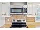 Close up of the kitchen area featuring stainless steel stove and microwave, granite countertops, and backsplash at 2264 Winding Way, Tucker, GA 30084