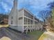 Rear view of a multi-story home with screened porches, situated in a wooded area at 3705 Tradewinds Dr, Cumming, GA 30041