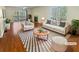 Bright, staged living room featuring hardwood floors, fireplace, and sliding glass door at 3705 Tradewinds Dr, Cumming, GA 30041