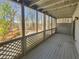 Relaxing screened porch with wood flooring, offering tranquil views of the surrounding trees and lake at 3705 Tradewinds Dr, Cumming, GA 30041