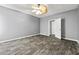 Bedroom with stylish wood-look flooring, ceiling fan, and a doorway leading to another room at 113 Willow Hill Ln, Stockbridge, GA 30281