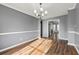 Open dining area featuring wood-look floors, neutral gray walls, and view of the kitchen at 113 Willow Hill Ln, Stockbridge, GA 30281