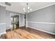 Open dining room with wood-look floors, neutral walls, and an opening to the kitchen at 113 Willow Hill Ln, Stockbridge, GA 30281