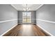 Bright dining room featuring modern chandelier, wood-look floors, and neutral gray walls at 113 Willow Hill Ln, Stockbridge, GA 30281