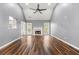 Open living room with a fireplace, vaulted ceiling, fan, wood-look floors, and neutral paint at 113 Willow Hill Ln, Stockbridge, GA 30281