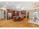 A view of the kitchen with hardwood floors, stainless steel appliances, a large island and dark wood cabinets at 19 Troup Ct, Acworth, GA 30101