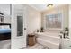 Large bathroom featuring a tub, storage and a large mirror attached to the ensuite entrance at 4150 E East Chapel Hill Rd, Douglasville, GA 30135