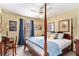 Traditional bedroom featuring a four-poster bed, wooden desk, and beautiful dog themed artwork at 4150 E East Chapel Hill Rd, Douglasville, GA 30135