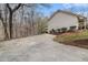 Long concrete driveway leading to the side of a house in a wooded area at 4150 E East Chapel Hill Rd, Douglasville, GA 30135